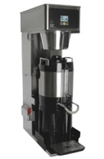 Commercial coffee brewing machine with a stainless steel exterior and a black carafe positioned under the dispenser.