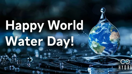 Text reads "Happy World Water Day!" next to a large water droplet containing an image of Earth, set against a blurred water surface with droplets. HYDR8 logo is at the bottom right.