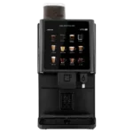 A black coffee vending machine with a touchscreen display showing various coffee options and a cup dispenser at the bottom.