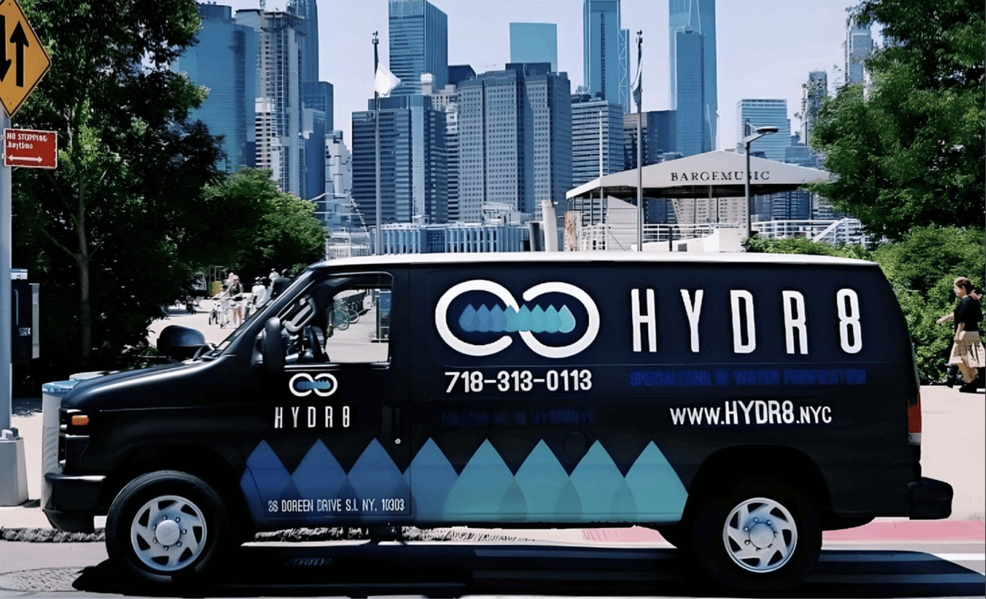 A black van with blue geometric designs and "HYDR8" branding is parked in front of the Brooklyn Bridge and New York City skyline.
